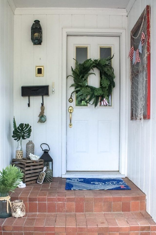 Front porch with beachy theme and blue welcome mat